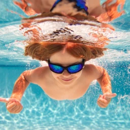boy with goggles swimming in a pool