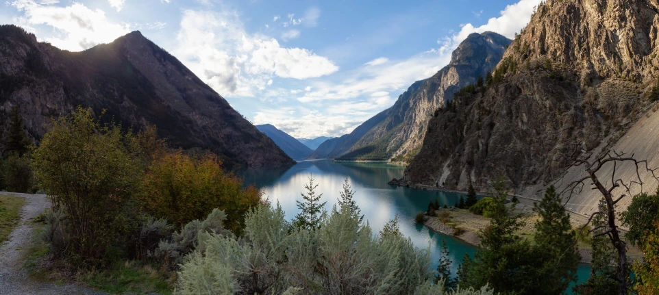 landscape photograph centred on a lake in a valley between mountains with trees in the foreground